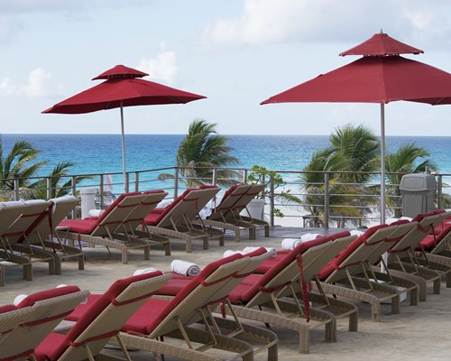 A view of chaise lounge chairs alongside the ocean.