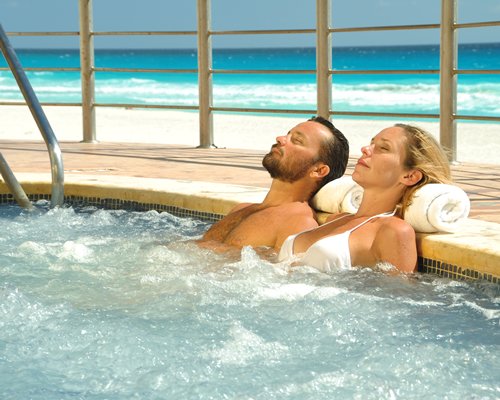 A couple enjoying in an indoor hot tub with an ocean view.