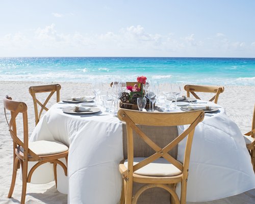 An outdoor dining table alongside the ocean.