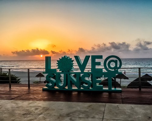 A view of the love sunset signboard alongside the ocean.