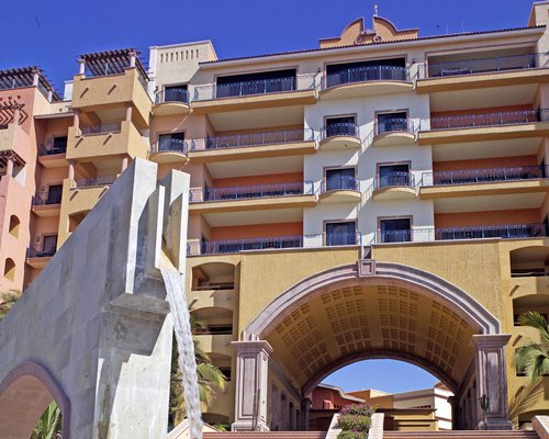 An exterior view of multi story resort units with a water feature.