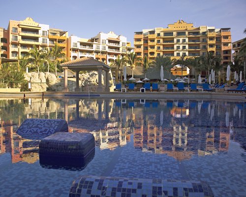 An exterior view of multi story resort units alongside a waterfront.
