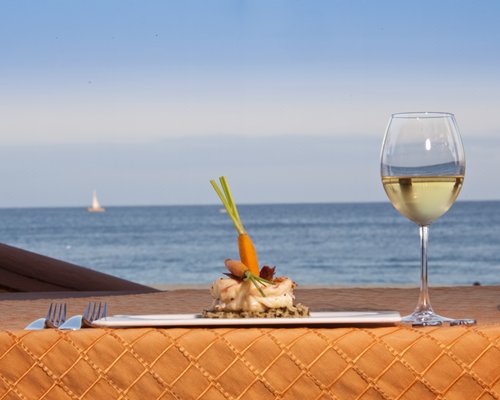 A food item on an outdoor table alongside the ocean.