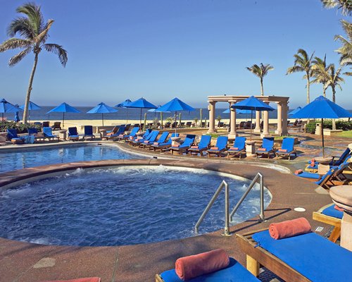 An outdoor swimming pool with chaise lounge chairs.
