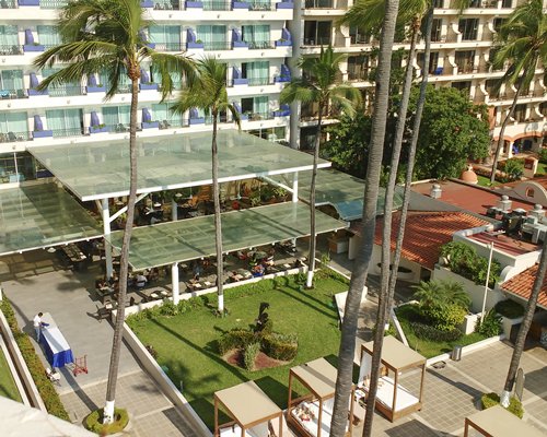 Scenic view of multiple unit balconies with an outdoor restaurant and beach beds.
