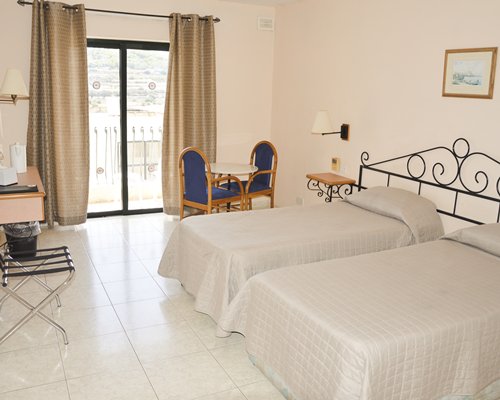 A well furnished bedroom with two beds and an outside view.