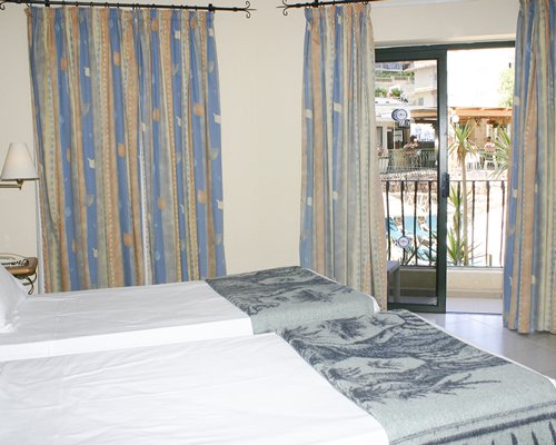 A well furnished bedroom with two beds and a balcony.