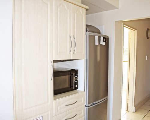 A kitchen with a microwave oven and refrigerator.
