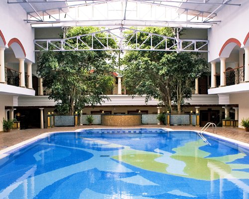 Indoor swimming pool with the view of multiple unit balconies.