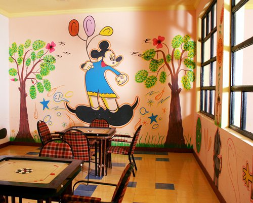 Indoor recreation room with carrom boards and outside view.
