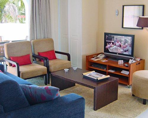 A well furnished living room with television and outside view.