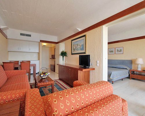 A well furnished living room with television and dining area.