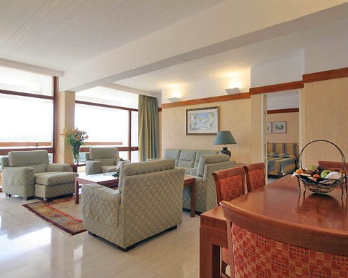 A well furnished living room with double pull out sofas alongside dining area.