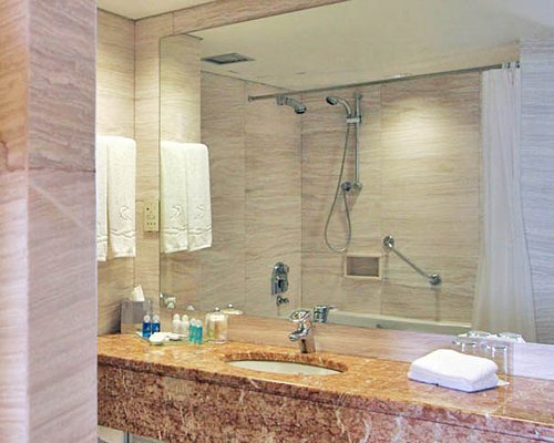 A bathroom with stand up shower and single sink vanity.