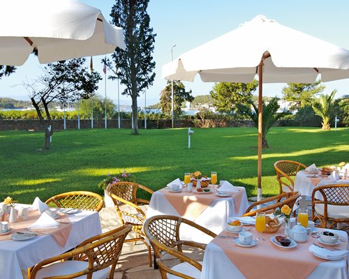 Outdoor dining area with sunshades and landscaping.