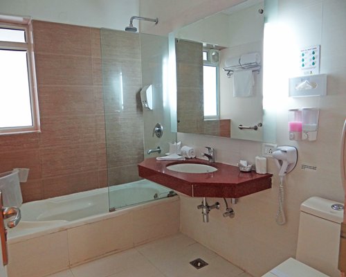 A bathroom with shower bathtub and sink.