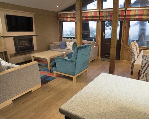 A well furnished living room with a television fireplace and an outside view.