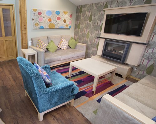 A well furnished living room with a television and fireplace.