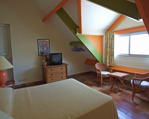 A well furnished bedroom with a television and an outside view.