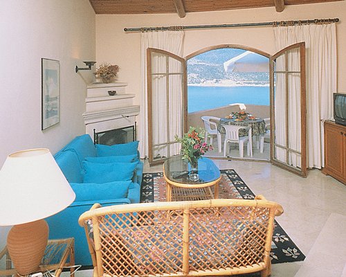 A well furnished living room with a television and balcony.