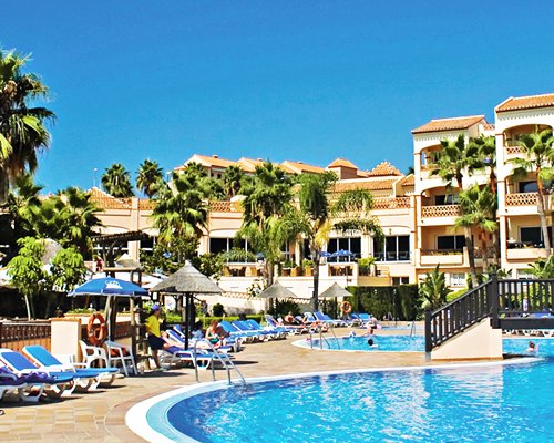 An outdoor swimming pool with chaise lounge chairs.