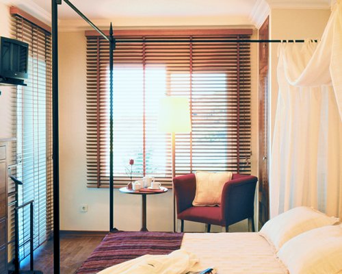A well furnished bedroom with a television and an outside view.