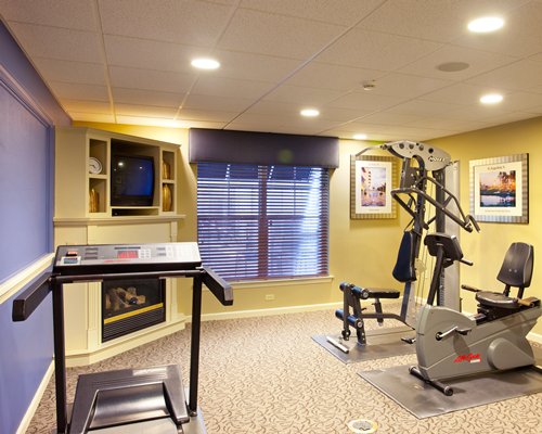 A well equipped fitness center with a television.