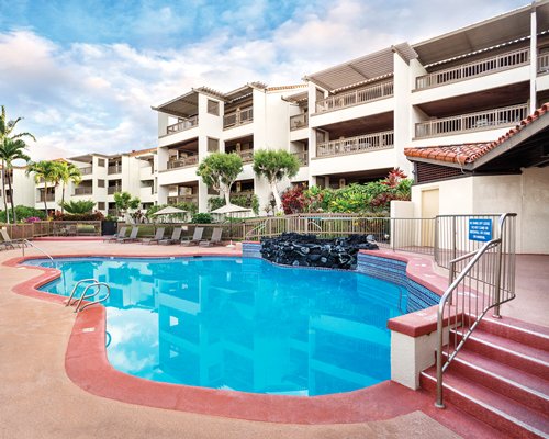 An outdoor swimming pool with chaise lounge chairs alongside the resort unit.