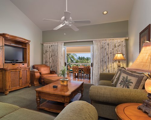 A well furnished living room with a television and balcony.