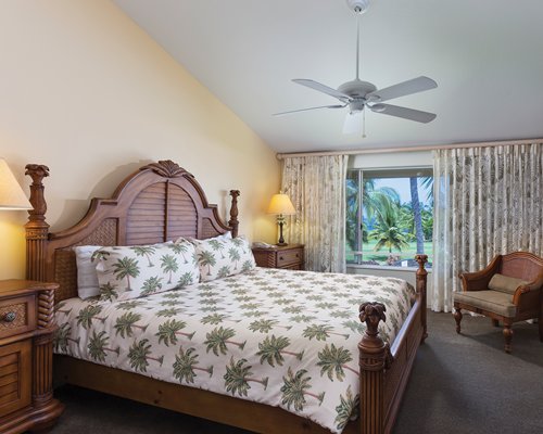 A well furnished bedroom with king bed and outside view.