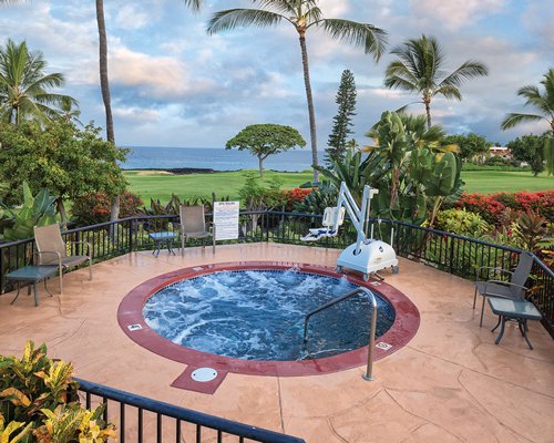 An outdoor hot tub with patio furniture.
