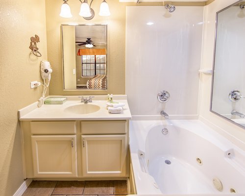 A well furnished bedroom with a bathtub shower and vanity.