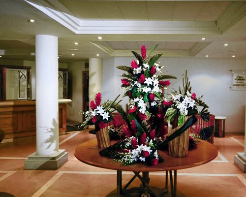 Resort reception area with a flower vase on a wooden table.