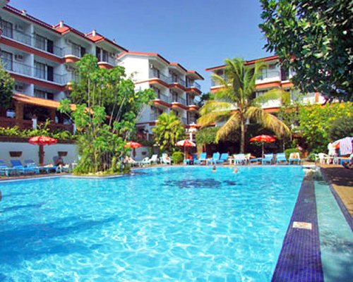 An outdoor swimming pool with chaise lounge chairs and patio furniture alongside the resort unit.