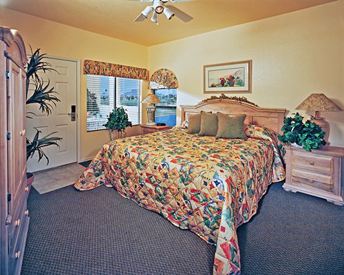 A well furnished bedroom with king bed and outside view.