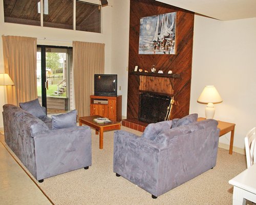 A well furnished living room with a television fireplace and an outside view.