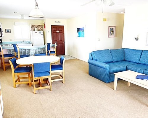 An open plan living and dining area alongside kitchen with a breakfast bar.