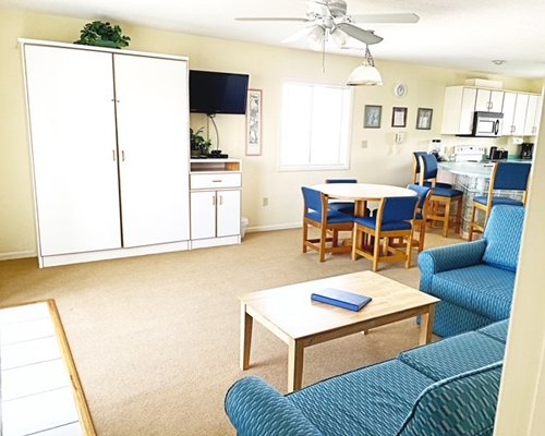 A well furnished dining area alongside a kitchen with a breakfast bar.