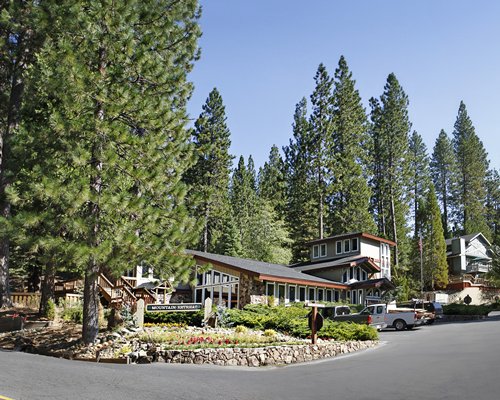 Street view of the Mountain Retreat resort with car parking surrounded by woods.