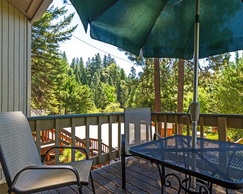 A balcony with patio and sunshade umbrella.