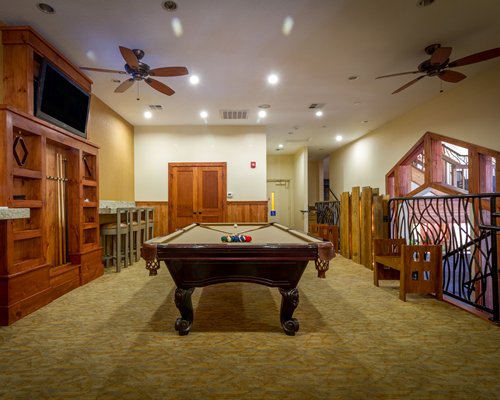 An indoor recreation room with pool table and television.