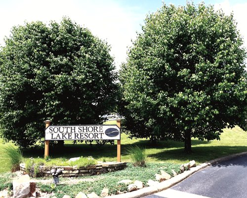 Signboard of South Shore Lake Resort surrounded by trees alongside the pathway.