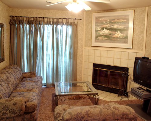 A well furnished living room with a television and a fireplace.