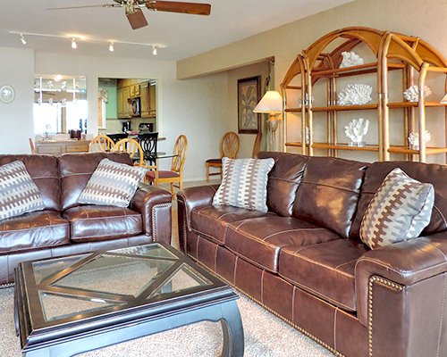 A well furnished living room with pull out sofas alongside kitchen and dining area.