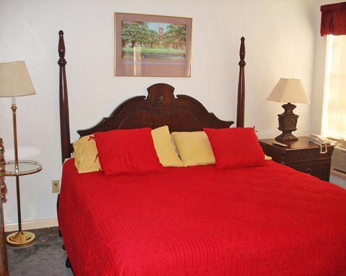 A well furnished bedroom with queen bed and two lamps.