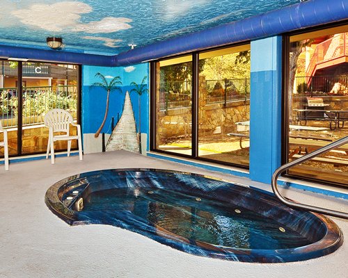 A view of an indoor hot tub with an outside view.