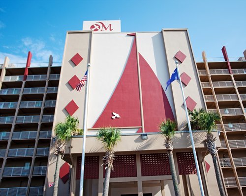 Exterior view of Maritime Beach Club with multiple balconies and palm trees.