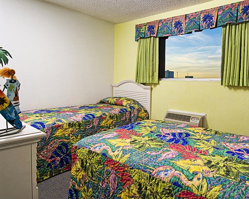 A well furnished bedroom with two beds and an outside view.