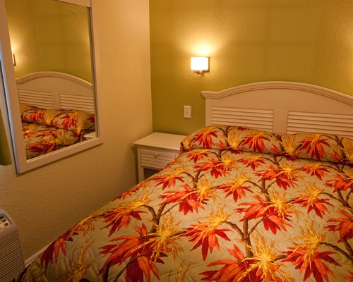 A well furnished bedroom with a mirror.