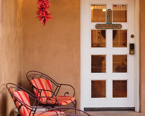 Entrance to a unit with outdoor patio chairs.